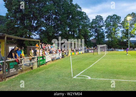 Fans und Zuschauer hinter Ziel stehen auf der Terrasse des Englischen untere Liga Football Ground Stockfoto