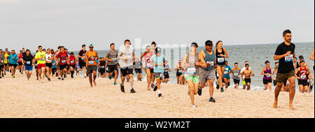 Babylon, New York, USA - 24. Juni 2019: Läufer Momente nach dem Start des Sommers Serie 1 Meile Rennen am Strand von Robert Moose Zustand ausführen Stockfoto