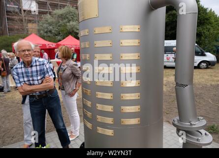 Bitterfeld Wolfen, Deutschland. 11. Juli, 2019. Die Teilnehmer der Gedenkfeier stehen an einem Denkmal in der Chemischen Park. Eine Stele erinnert an die Opfer der chemischen Unfall vom 11.07.1968, bei der 40 Menschen starben und mehr als 240 wurden verletzt. Credit: Sebastian Willnow/dpa-Zentralbild/ZB/dpa/Alamy leben Nachrichten Stockfoto