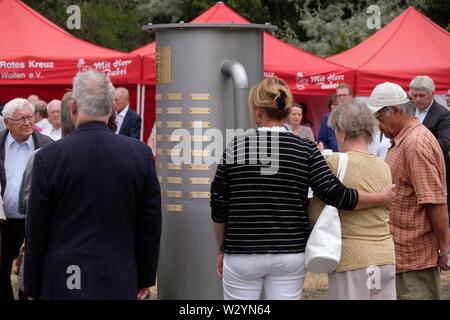 Bitterfeld Wolfen, Deutschland. 11. Juli, 2019. Die Teilnehmer der Gedenkfeier stehen an einem Denkmal in der Chemischen Park. Eine Stele erinnert an die Opfer der chemischen Unfall vom 11.07.1968, bei der 40 Menschen starben und mehr als 240 wurden verletzt. Credit: Sebastian Willnow/dpa-Zentralbild/dpa/Alamy leben Nachrichten Stockfoto