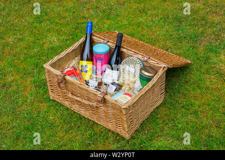 Luxuriöse Lebensstil: Fortnum & Mason rattan Picknickkorb (The Grosvenor behindern) auf Gras mit einem oben offenen Darstellung von Inhalten Stockfoto