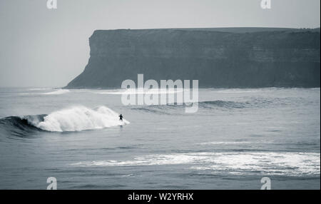 Surfer auf einer Welle an saltburn am Meer, North Yorkshire, England. Großbritannien Stockfoto