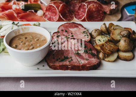 Traditionelle Luxemburger Gericht Judd mat Gaardebounen, geräucherte Kragen Schweinefilet mit Bohnen, auf einem Schild neben kalte Fleischplatte, selektive konzentrieren. Stockfoto