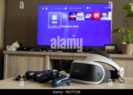 Brecht, Antwerpen, Belgien - 6. Juni 2019: Ein Schuss von einige Playstation 4 Controller mit der Playstation VR-Headset vor einem Fernseher, in dem die Stücke Stockfoto