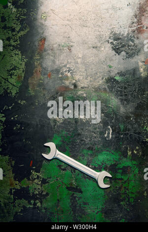 Ein Schlüssel liegt auf einem Metall Werkbank mit Spuren von Arbeit und geschliffen Farbe. Stockfoto