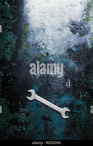 Ein Schlüssel liegt auf einem Metall Werkbank mit Spuren von Arbeit und geschliffen Farbe. Stockfoto