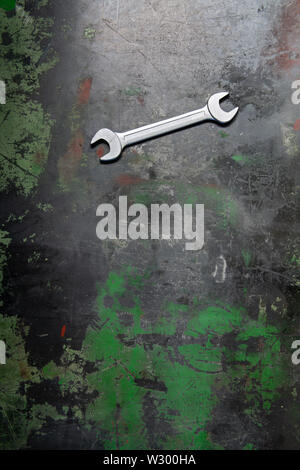 Ein Schlüssel liegt auf einem Metall Werkbank mit Spuren von Arbeit und geschliffen Farbe. Stockfoto
