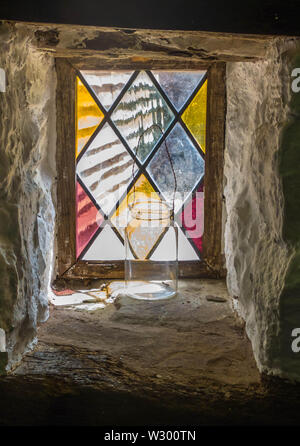 Glas Glas vor Holz gerahmt Glasfenster, mit weiß getünchten Steinwänden. Stockfoto