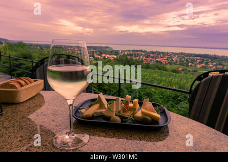 Wein, Käse Tabelle über den Balaton auf dem Hügel, Abendessen, Mittagessen, romantisches Date, Picknick, Essen auf die Natur. Csopak Wein Restaurant bei Sonnenuntergang Ungarn Stockfoto