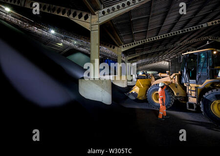 Bergbau, Verwaltung und Transport von Titanmineralsanden. Im Inneren des Ilmenit- und Rutil-Lagerhauses. Transport von Ilmenit vom Bunker zum Lastförderer. Stockfoto