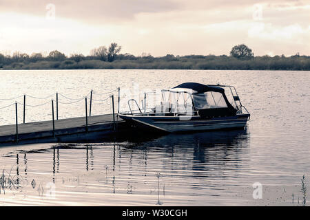 Kleines Boot am Pier auf dem Fluss. Stockfoto