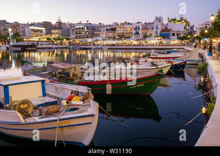 Fischerboote entlang des Lake Voulismeni in Agio Nikolaos in Abend, Kreta, Griechenland Stockfoto