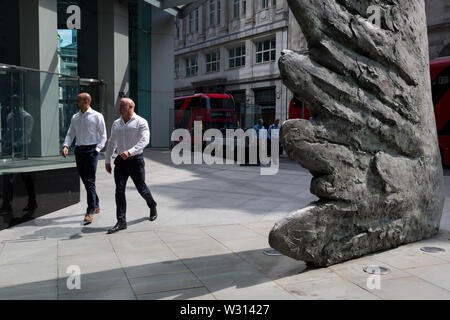 Finanzindustrie Geschäftsleute Spaziergang, vorbei an der Skulptur Stadt Flügel auf Threadneedle Street in der City von London, das Finanzviertel der Hauptstadt (aka der Square Mile), am 11. Juli 2019 in London, England. Stadt Flügel wird von dem Künstler Christopher Le Brun. Die zehn Meter hohe Bronzeskulptur wird von dem Präsidenten der Königlichen Akademie der Künste, Christopher Le Brun, von hammerson im Jahr 2009 in Betrieb genommen. Es wird "die Stadt Flügel" und wurde von der Morris Sänger Kunst Gründer, angeblich der älteste Gießerei in die Welt geworfen wurde. Stockfoto