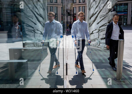 Finanzindustrie Geschäftsleute Spaziergang, vorbei an der Skulptur Stadt Flügel auf Threadneedle Street in der City von London, das Finanzviertel der Hauptstadt (aka der Square Mile), am 11. Juli 2019 in London, England. Stadt Flügel wird von dem Künstler Christopher Le Brun. Die zehn Meter hohe Bronzeskulptur wird von dem Präsidenten der Königlichen Akademie der Künste, Christopher Le Brun, von hammerson im Jahr 2009 in Betrieb genommen. Es wird "die Stadt Flügel" und wurde von der Morris Sänger Kunst Gründer, angeblich der älteste Gießerei in die Welt geworfen wurde. Stockfoto