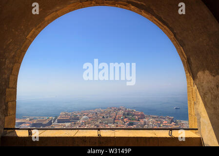 Panoramablick über die Stadt Neapel durch den Bogen der mittelalterlichen Festung Castel Sant'Elmo. Skyline und den Golf von Neapel, Kampanien, Italien. Stockfoto