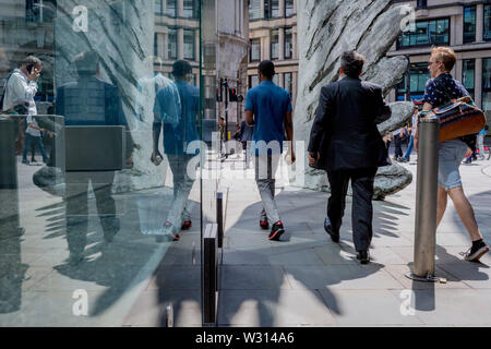 Finanzindustrie Geschäftsleute Spaziergang, vorbei an der Skulptur Stadt Flügel auf Threadneedle Street in der City von London, das Finanzviertel der Hauptstadt (aka der Square Mile), am 11. Juli 2019 in London, England. Stadt Flügel wird von dem Künstler Christopher Le Brun. Die zehn Meter hohe Bronzeskulptur wird von dem Präsidenten der Königlichen Akademie der Künste, Christopher Le Brun, von hammerson im Jahr 2009 in Betrieb genommen. Es wird "die Stadt Flügel" und wurde von der Morris Sänger Kunst Gründer, angeblich der älteste Gießerei in die Welt geworfen wurde. Stockfoto