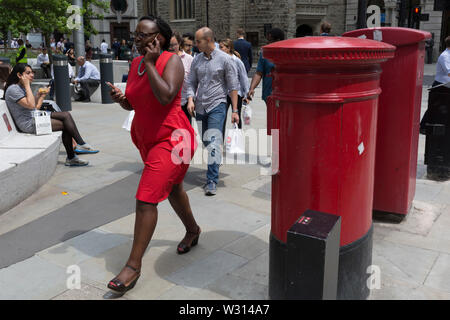 Eine Geschäftsfrau zu Fuß und Vorträge zur leadenhall in der Stadt London, der Bezirk der Hauptstadt (aka der Square Mile), am 10. Juli 2019 in London, England. Stockfoto