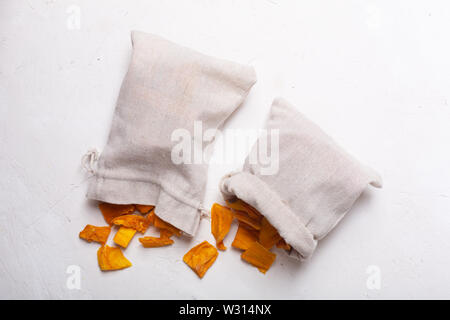 Mango Chips in einem Stoffbeutel auf weißem Hintergrund Stockfoto