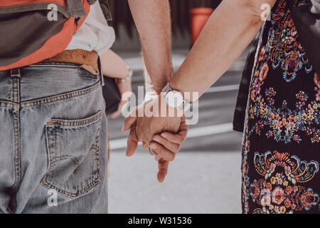 Nahaufnahme von nicht identifizierten Kaukasischen Paar Hände halten in der Öffentlichkeit, liebe Konzept, selektive konzentrieren. Stockfoto