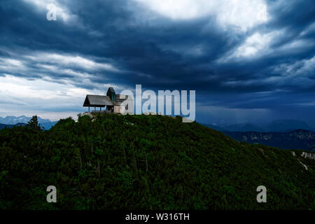 Dramatische Mountain Sky mit Gewitterwolken und Berg Kapelle (tabor) auf dem Hochfelln Berg in Bayern in der Nähe von Chiemse Stockfoto