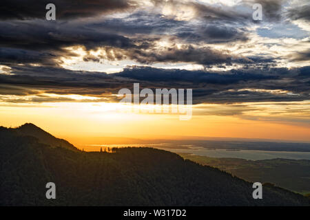 Schönen Sonnenuntergang über den Chiemsee mit bewölktem Himmel auf Hochfelln Berg Stockfoto