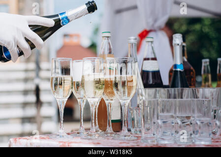 Barkeeper gießt Champagner. Eine Menge Weingläser mit kühlen leckeren Sekt oder Weißwein. Party und Urlaub feier Konzept Stockfoto