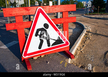 Im Bau. In Arbeit. Baustellen, Verkehrszeichen. Männer an die Arbeit. Bau eines neuen Radweg oder Bürgersteig Stockfoto