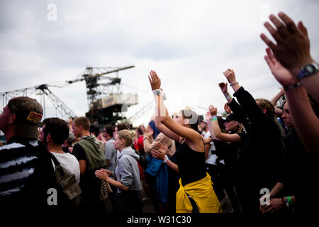 11 Juli 2019, Sachsen-Anhalt, Gräfenhainichen: Besucher feiern vor der Mainstage auf dem Splash Festival. Die Hip Hop und Reggae Festival auf der Halbinsel Ferropolis in der Nähe von Gräfenhainichen findet vom 11. bis 13. Juli 2019. Foto: Alexander Prautzsch/dpa Stockfoto