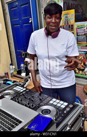 Schwarze weibliche DJ einrichten Musik außerhalb Schaufenster auf zwei Decks mischen an der Bristol St Paul's Karneval Stockfoto