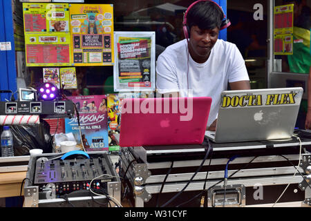 Schwarze weibliche DJ einrichten Musik außerhalb Schaufenster auf zwei Decks mischen an der Bristol St Paul's Karneval Stockfoto