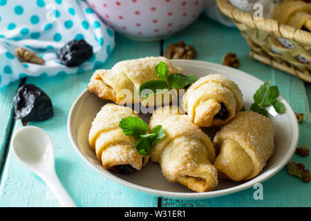 Hausgemachte Kekse mit Backpflaumen und Nüssen auf einem rustikalen Holztisch. Stockfoto