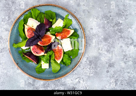 Feinkost Salat mit Feigen und Käse auf grau blau hintergrund Stockfoto