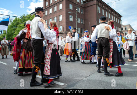 Tallinn, Estland, 6. Juli, 2019: Die Menschen in traditionellen estnischen Kleidung tanzen auf den Straßen von Tallinn in einer Parade zum Song Festival Gelände Stockfoto