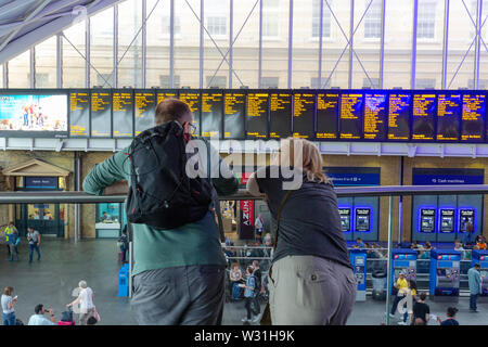 Der Bahnhof Kings Cross London: Ein paar Fahrgäste am Bahnhof Abfahrt board aus der Bahnhofshalle suchen, Kings Cross Bahnhof, London UK Stockfoto