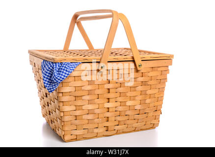 Eine braune Rattan Picknickkorb auf weißem Hintergrund mit kariertem Tuch Stockfoto