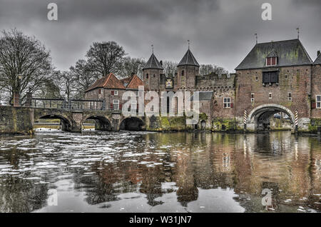 Amersfoort, Niederlande, 26. Februar 2017: 14. Jahrhundert Koppelpoort über den Fluss Eem und einem angrenzenden Brücke über den Beek an einem grauen Tag in Stockfoto