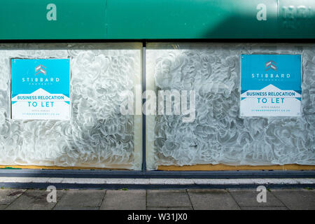 Die weiß getünchten Windows einer nicht besetzten geschlossen UK High Street Shop, Büro Einheit ist dargestellt in Swindon, Wiltshire Stockfoto