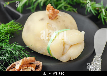 Frischen, traditionellen Süditalienischen Kuh oder Ziege und Schaf Käse semi-soft Caciocavallo, der Scamorza ist einsatzbereit. Liegt auf schwarzen Original Platte. Stockfoto