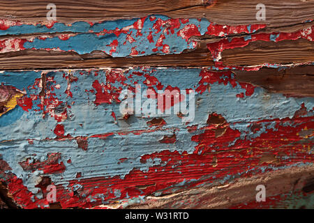 Blaue und rote alte Farbe blättert auf einem Holzbrett, abstrakter Hintergrund