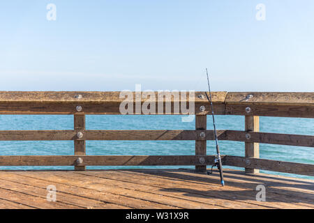 Angeln Polen lehnte sich auf einer Schiene auf einem Pier in Ventura Los Angeles Stockfoto