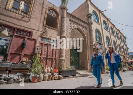 Kashgar, China. 16 Apr, 2019. Kinder in ihren Schuluniformen am Hintereingang des Id kah-Moschee in Kashgar gesehen. Die Provinz Xinjiang im Nordwesten von China gelegen ist, ist es die grösste Provinz in China. Mehrheit der Bevölkerung sind Muslime in Xinjiang. Vor kurzem hat die chinesische Regierung durchgesetzt Ein massiver Sicherheit Durchgreifen in Xinjiang, wo mehr als eine Million ethnischer Uiguren und andere meist muslimischen Minderheiten geglaubt werden, die in einem Netzwerk von Internierungslager, dass Peking beschreibt als ''berufliche Bildung Zentren' zur Lenkung Leute weg von gehalten Stockfoto