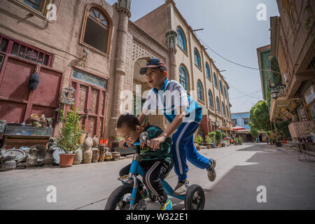 Kashgar, China. 16 Apr, 2019. Kinder in ihren Schuluniformen am Hintereingang des Id kah-Moschee in Kashgar gesehen. Die Provinz Xinjiang im Nordwesten von China gelegen ist, ist es die grösste Provinz in China. Mehrheit der Bevölkerung sind Muslime in Xinjiang. Vor kurzem hat die chinesische Regierung durchgesetzt Ein massiver Sicherheit Durchgreifen in Xinjiang, wo mehr als eine Million ethnischer Uiguren und andere meist muslimischen Minderheiten geglaubt werden, die in einem Netzwerk von Internierungslager, dass Peking beschreibt als ''berufliche Bildung Zentren' zur Lenkung Leute weg von gehalten Stockfoto