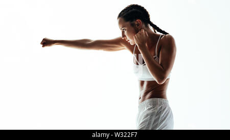 Fitness-Frau macht Boxtraining. Eine Frau, die Boxen übt und einen Schlag vor weißem Hintergrund wirft. Stockfoto