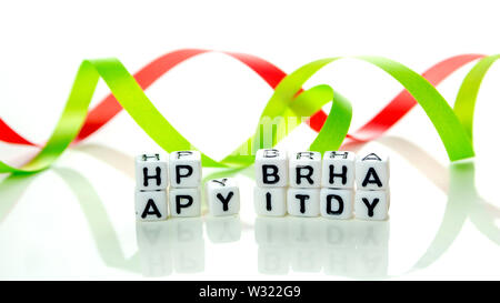 Happy Birthday Special unkonventionelle Karte aus weißer Würfel mit schwarzen Buchstaben und grün Geburtstag Dekorationen auf weißem Hintergrund Stockfoto