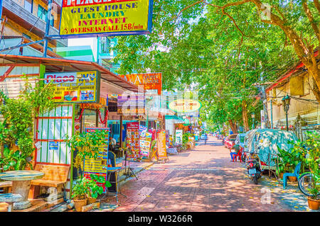 BANGKOK, THAILAND - 22. APRIL 2019: Die schmalen schattigen Straße mit zahlreichen Restaurants, Geschäften, Hotels und Reisebüros ist ein absolut leer während Stockfoto