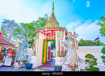 BANGKOK, THAILAND - 22. APRIL 2019: Die wunderschön gestalteten Eingangstore zum Wat Pho Tempel mit Skulpturen von Erziehungsberechtigten und bunten Fliesen- förmigen Stockfoto