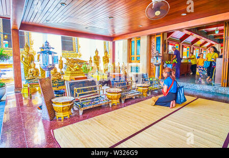 BANGKOK, THAILAND - 22 April, 2019: Die Frau betet Sitzen auf den Knien vor der kleinen Altar der Sala Rai Schrein im Wat Pho Tempel, am 22. April in Stockfoto