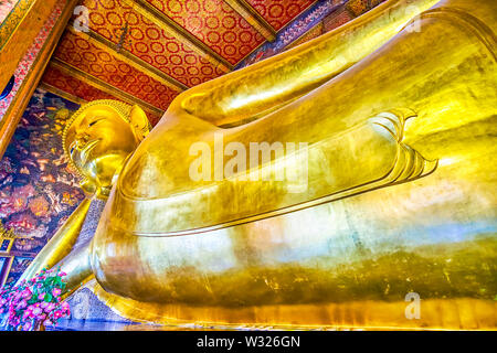 BANGKOK, THAILAND - 22 April, 2019: Der wunderschöne goldene Statue des Liegenden Buddha während erreichen Nirvana in der Kapelle des Liegenden Buddha, Wat Pho Stockfoto