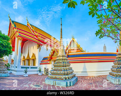 Blick auf den Innenhof des Wat Pho religion Komplex mit kleinen Stupas und großen West Viharn mit der Wand, Bangkok, Thailand Stockfoto