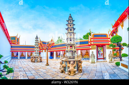 BANGKOK, THAILAND - 22 April, 2019: Die kleinen Hof von Phra Rabiang Kreuzgang mit Gilden Buddhas in überdachten Galerie und zwei steinerne Türme in der Mitte, Stockfoto